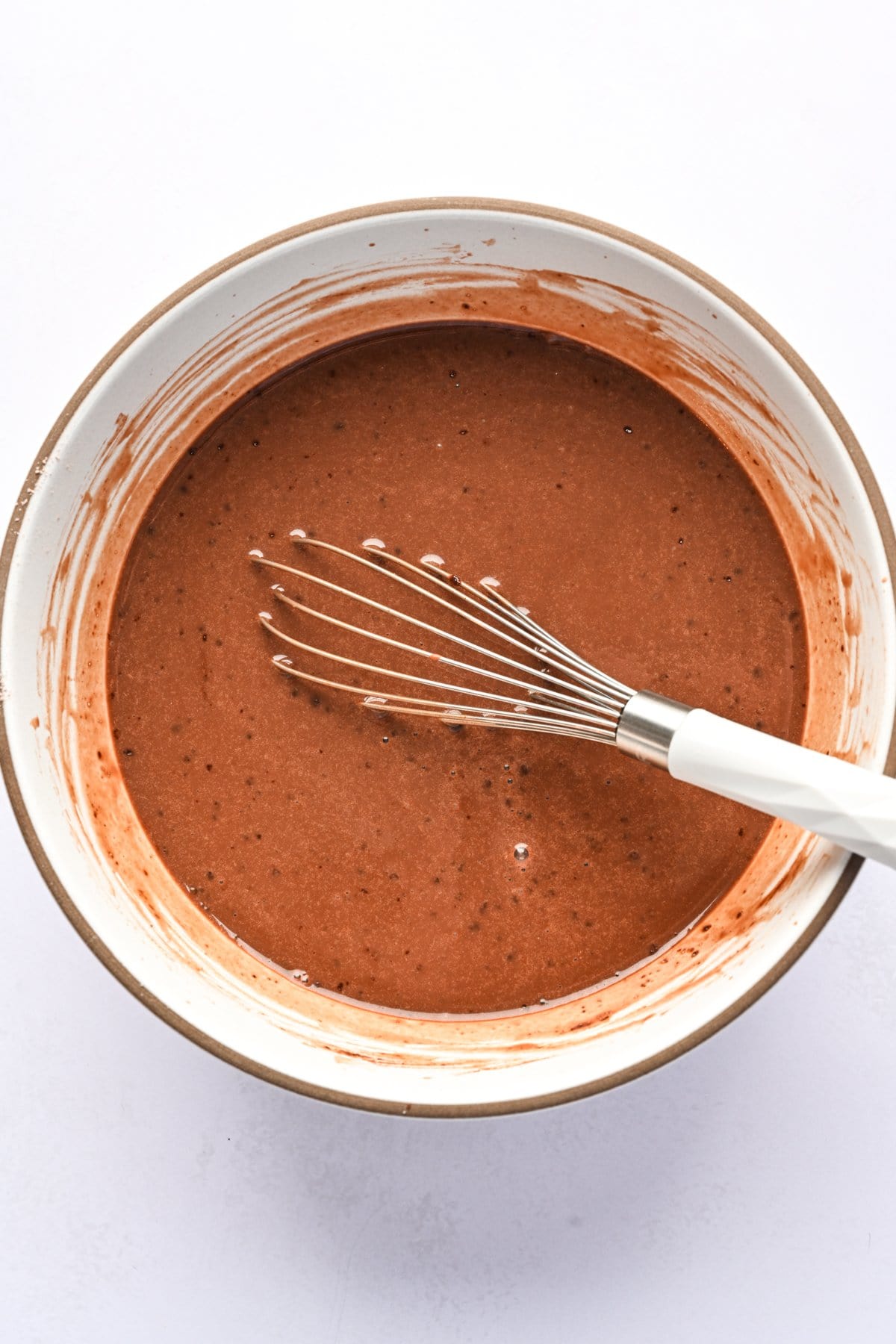 Chocolate pudding mixture in a bowl with whisk.