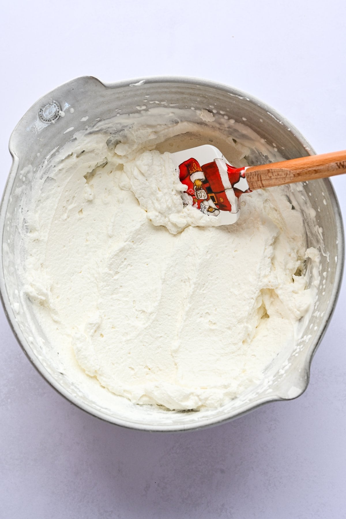 Overhead view of whipped cream in a bowl.
