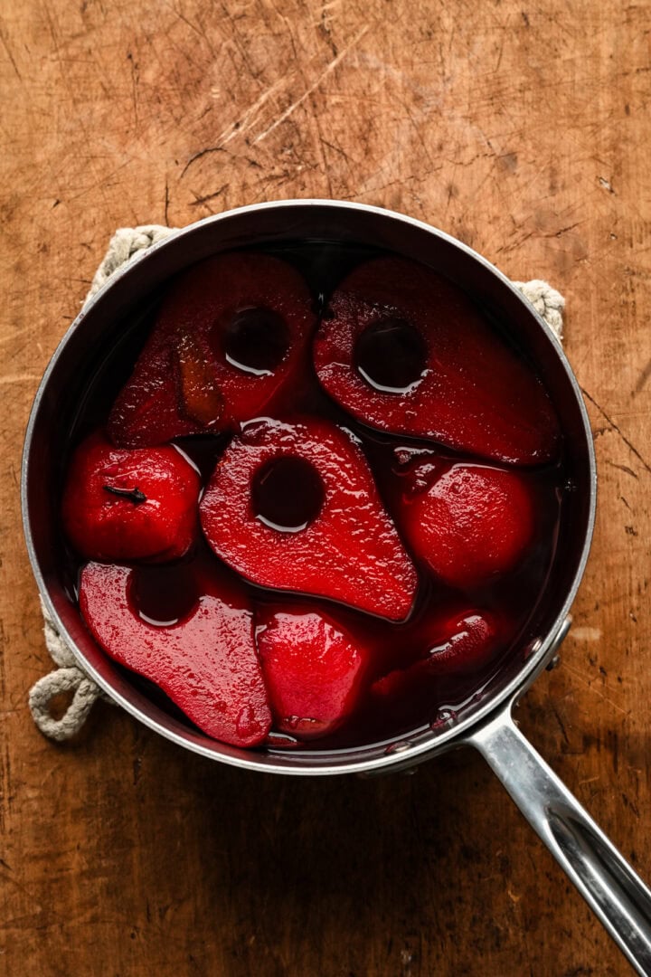 overhead view of pears in poaching liquid after being cooked.