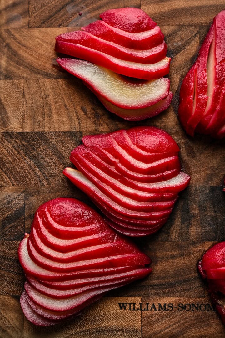 Sliced poached pears on cutting board. 
