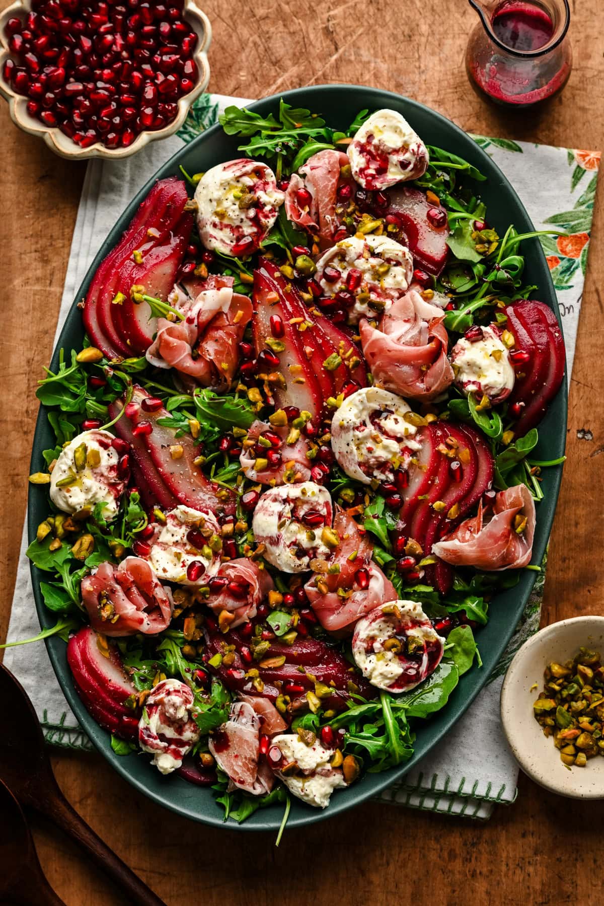 Overhead view of salad with burrata, prosciutto and poached pears on a platter.