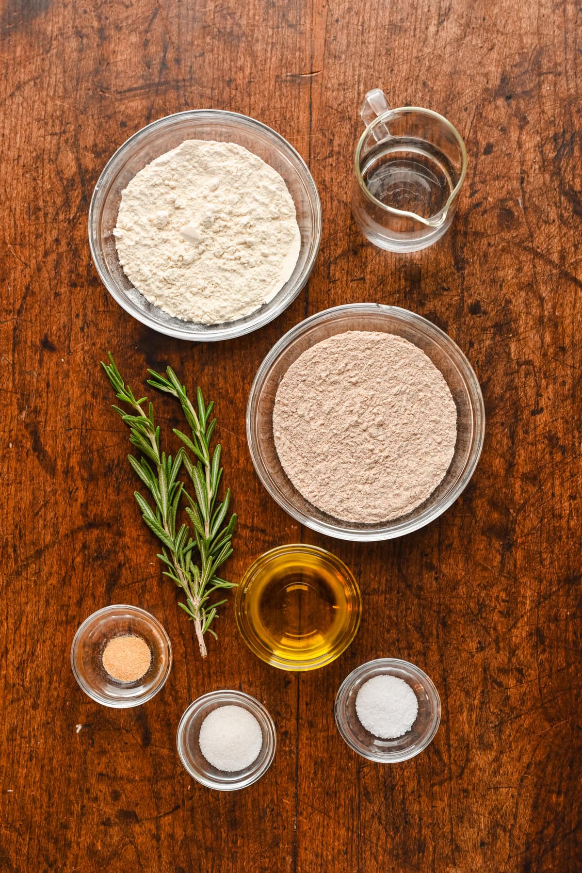 Overhead view of cracker ingredients, including rosemary and flour.