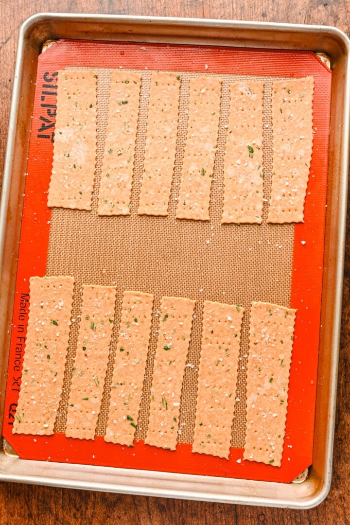 Crackers on silpat on top of a baking sheet.