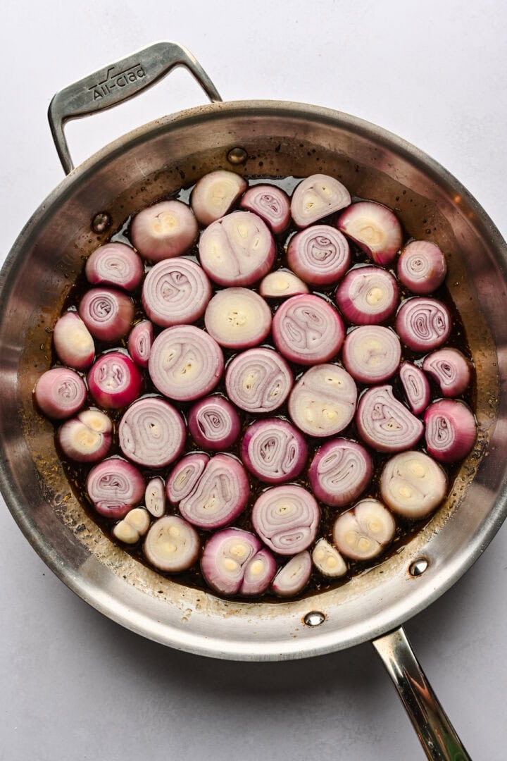 Shallot slices arranged atop the balsamic caramel in the skillet.