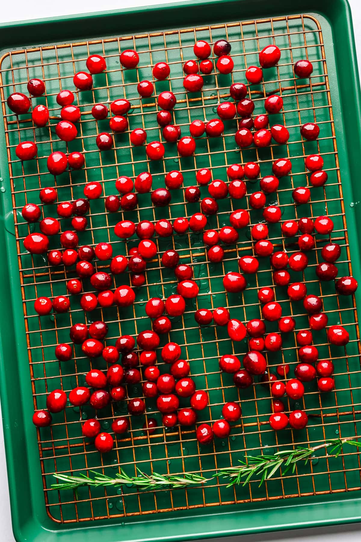 Cranberries coated in syrup on a wire rack to dry out.