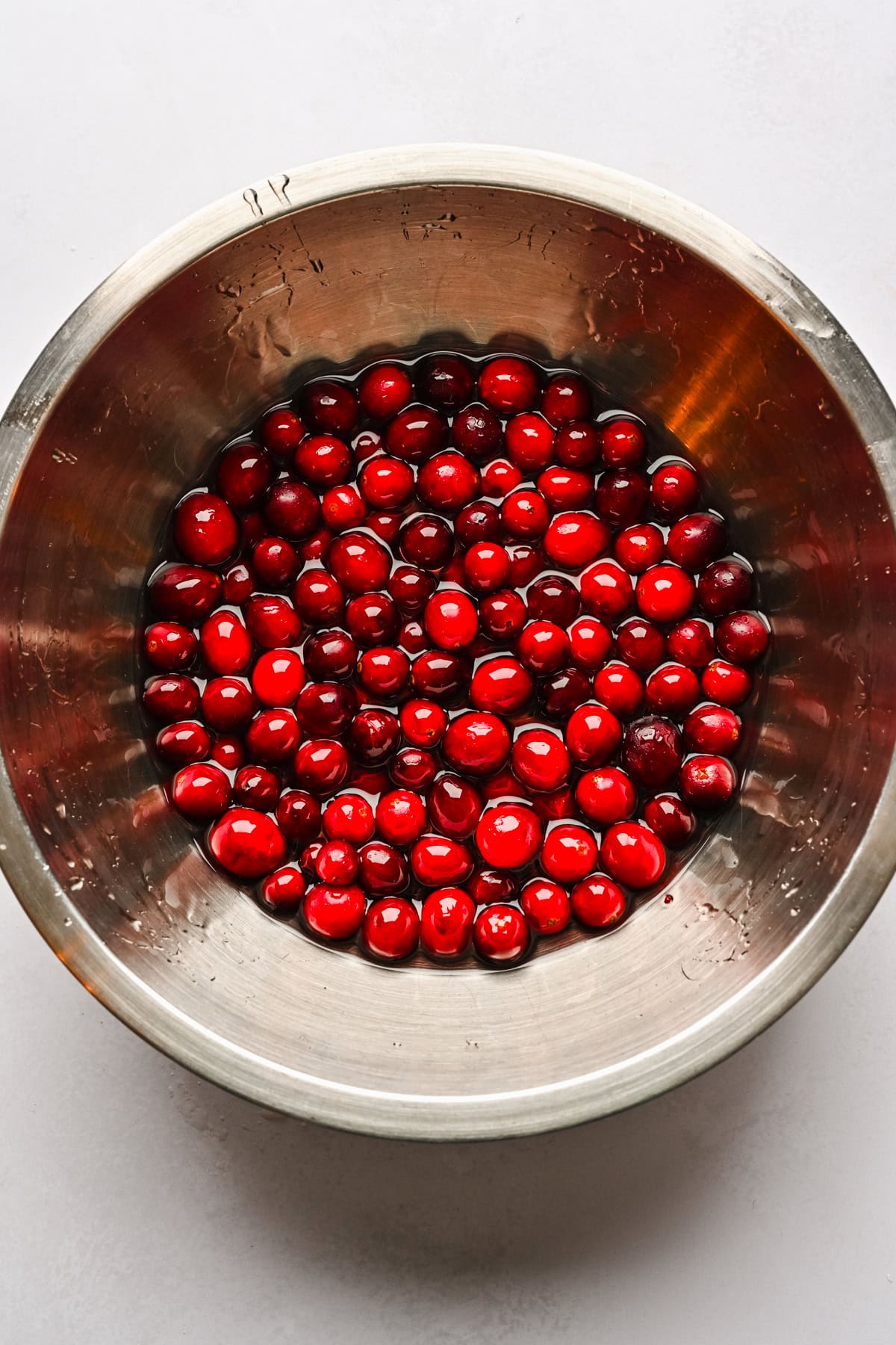 Fresh cranberries soaking in simple syrup.