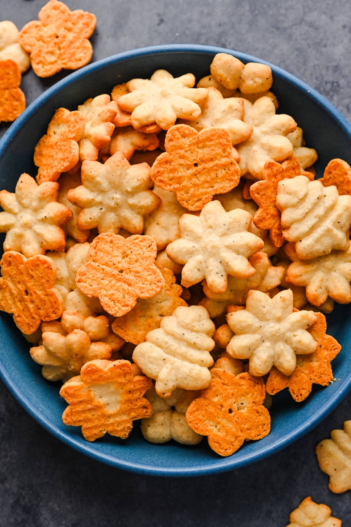 White Cheddar Parmesan Spritz crackers in a blue bowl.