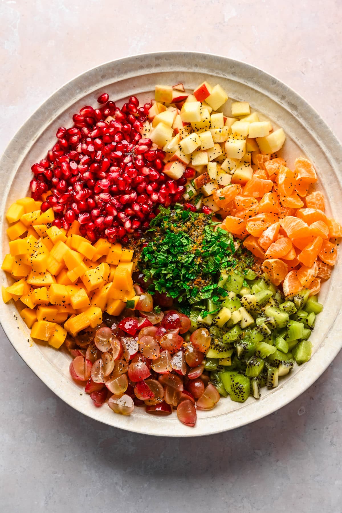 Winter fruit salad ingredients in large bowl before mixing.