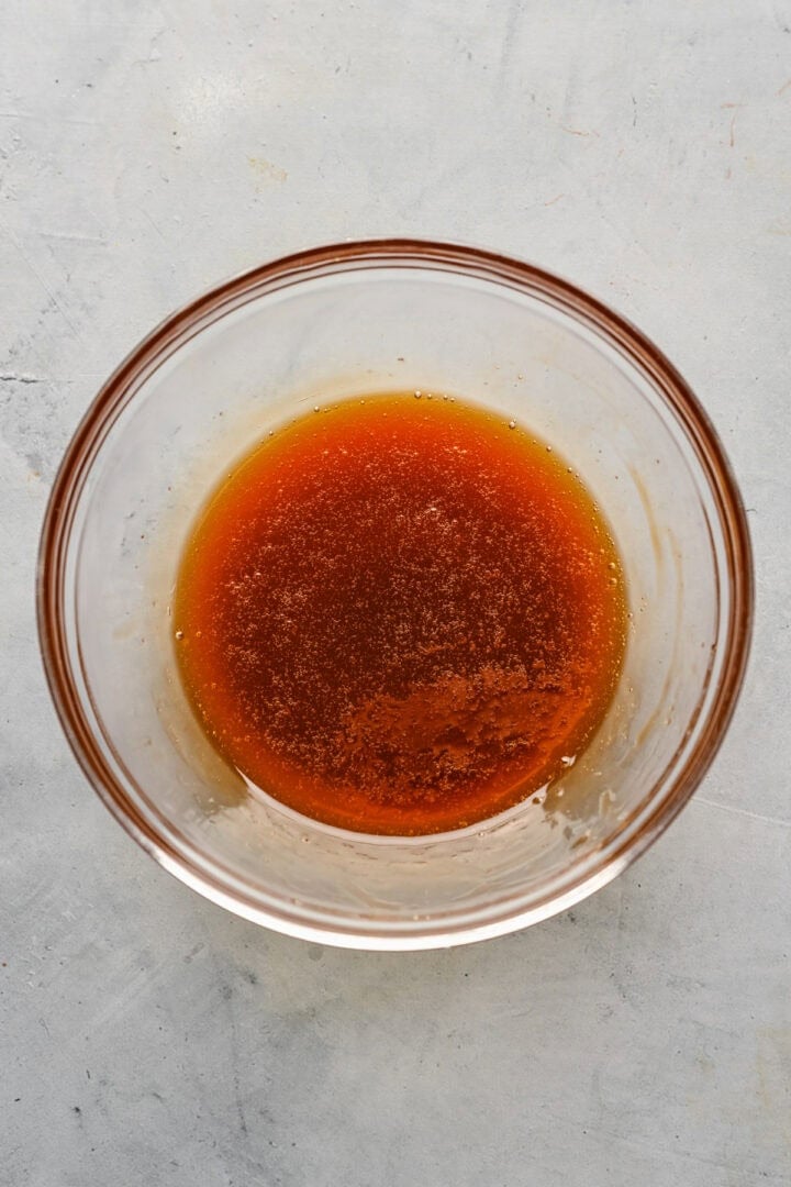 Overhead view of brown rice syrup and vanilla mixture in a glass bowl.