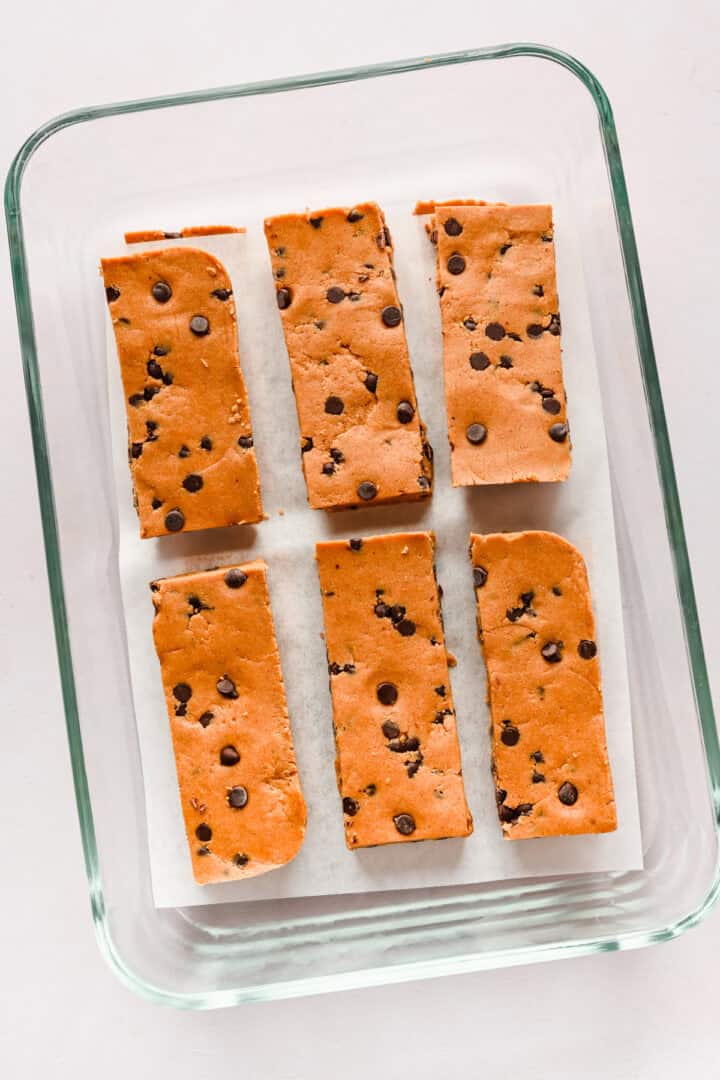 Overhead view of cut protein bars in a storage container.