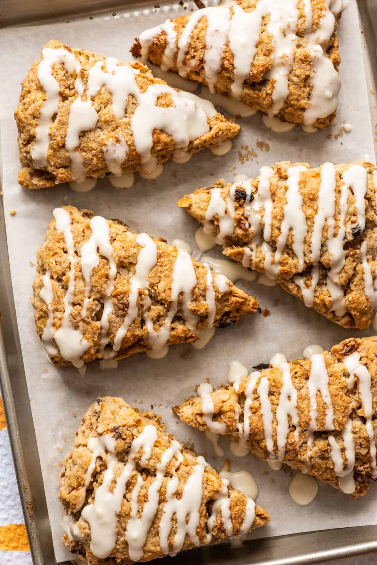 Overhead view of baked carrot cake scones with cream cheese glaze.