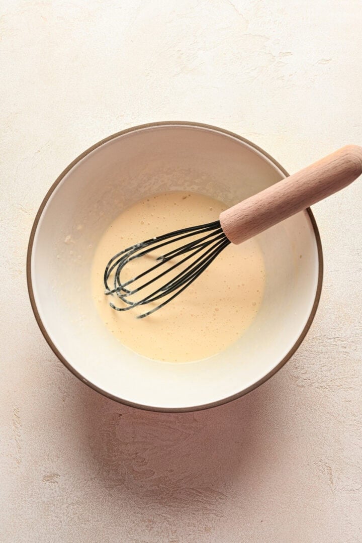 Wet ingredients in a bowl with whisk.