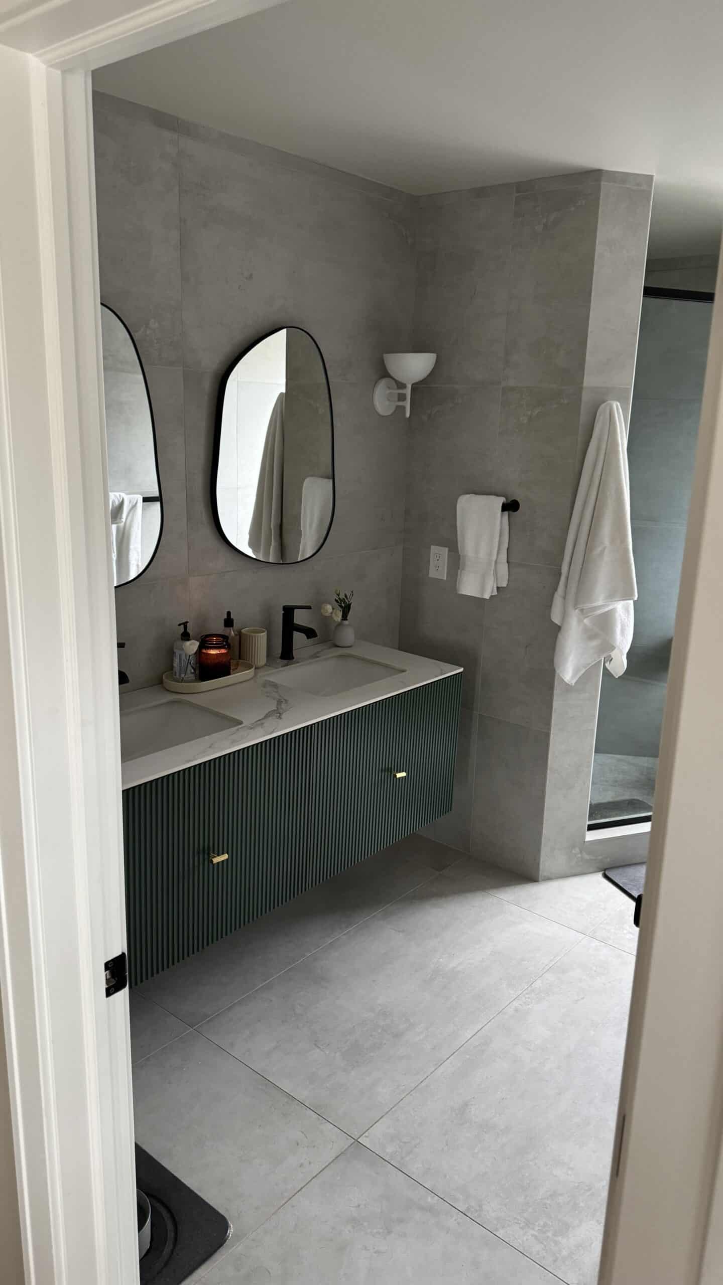 Bathroom with grey tile and green vanity.