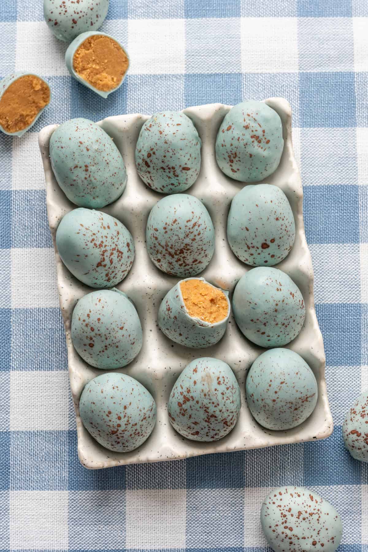 Overhead view of peanut butter Easter eggs that look like robin's eggs in egg container.