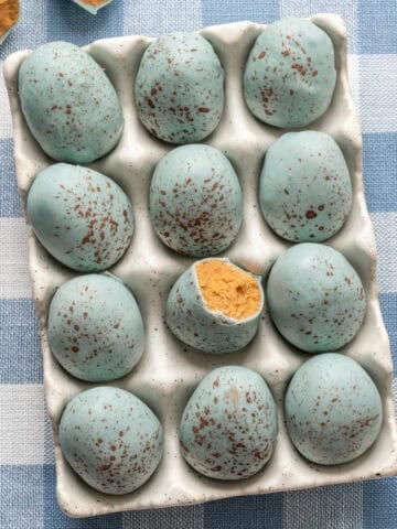 Overhead view of peanut butter Easter eggs that look like robin's eggs in egg container.