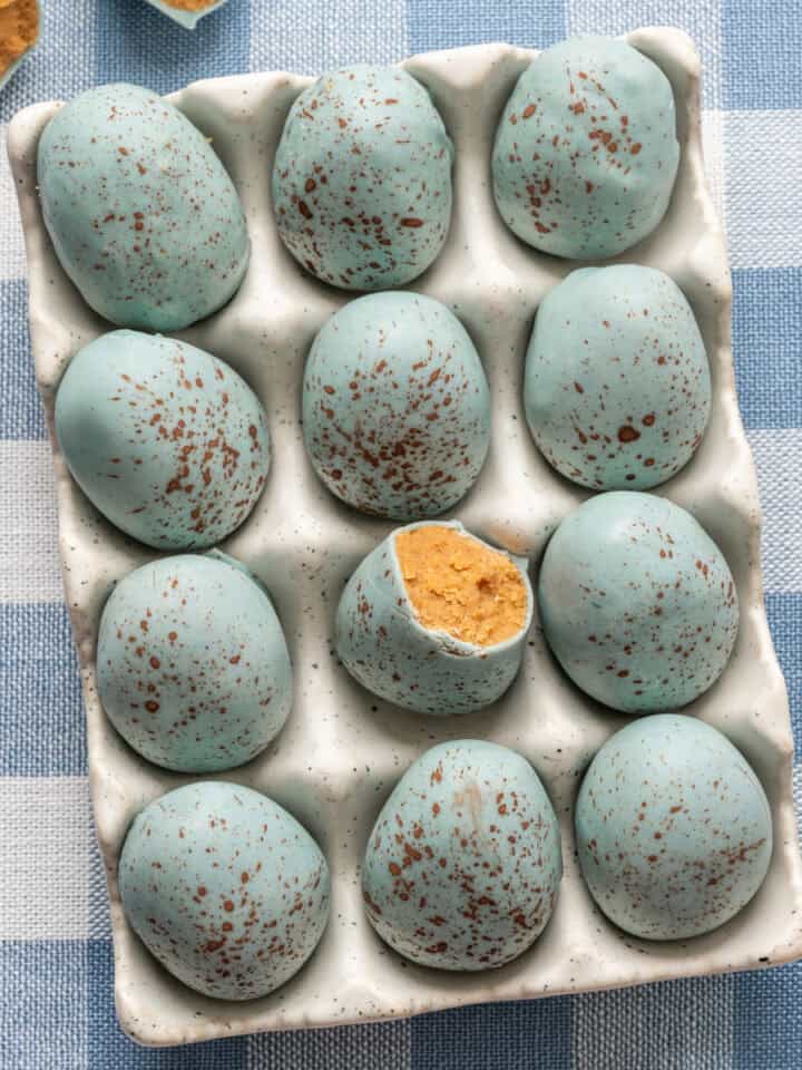 Overhead view of peanut butter Easter eggs that look like robin's eggs in egg container.