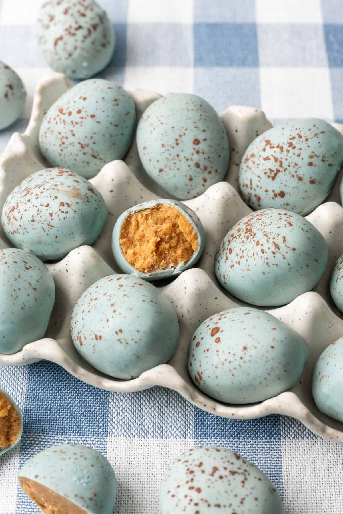 Side view of peanut butter Easter eggs that look like robin's eggs in egg container.