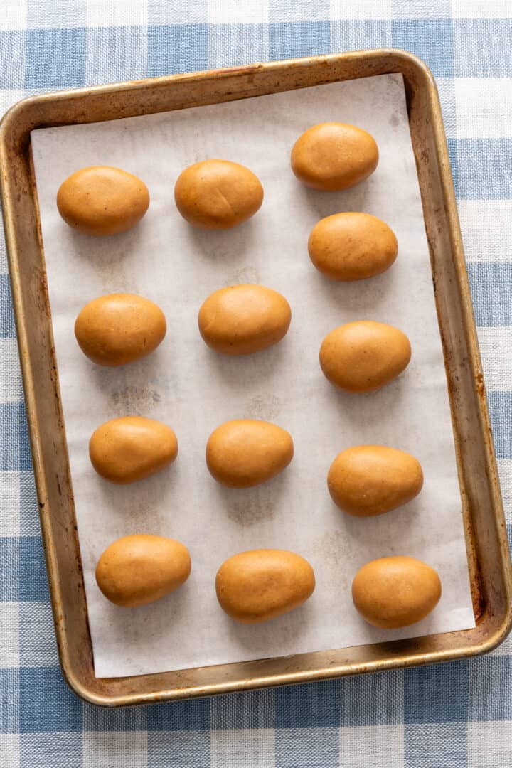 peanut butter filling shaped into eggs on baking sheet.