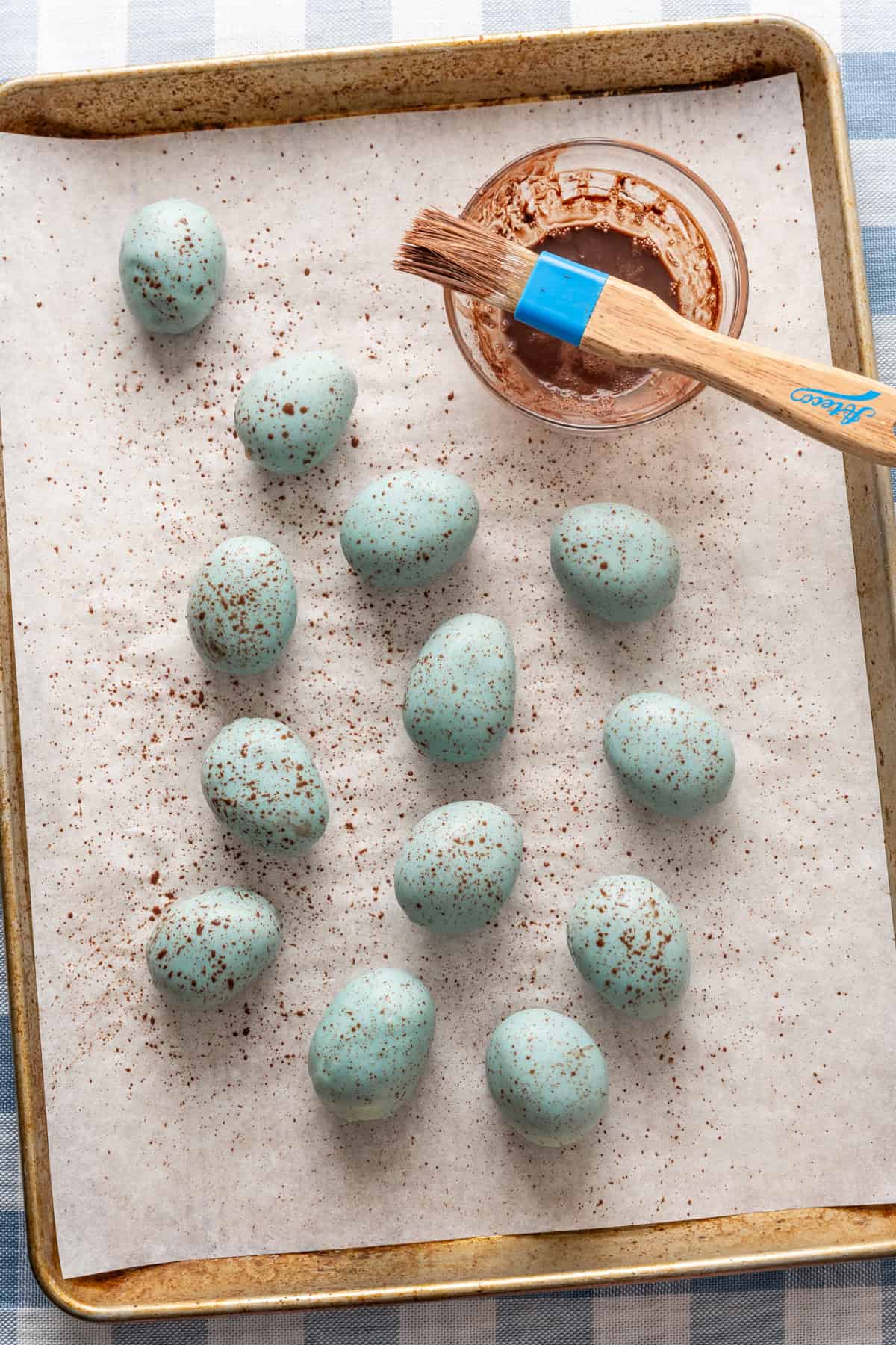 Speckled blue peanut butter eggs on sheet pan.