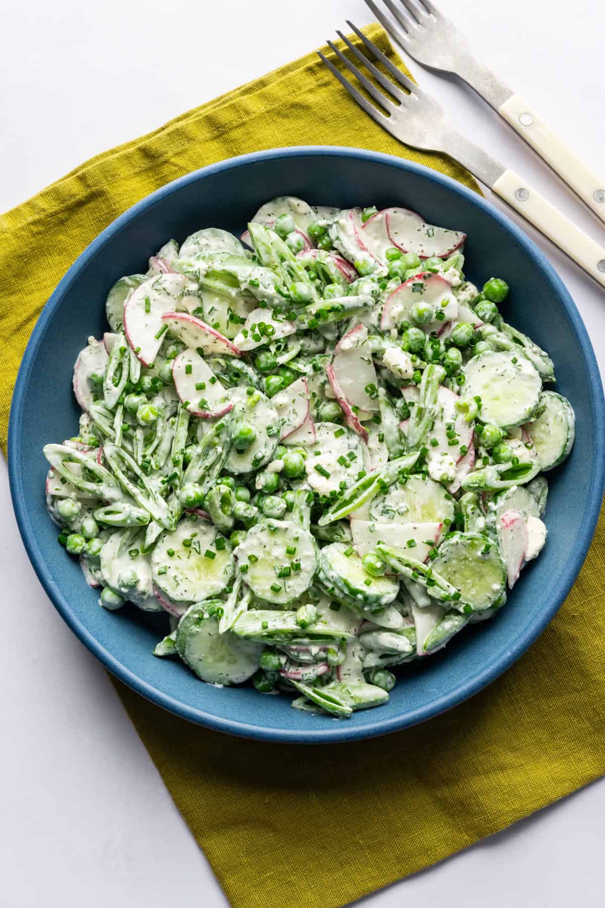 Overhead view of creamy cucumber pea salad in a bowl.