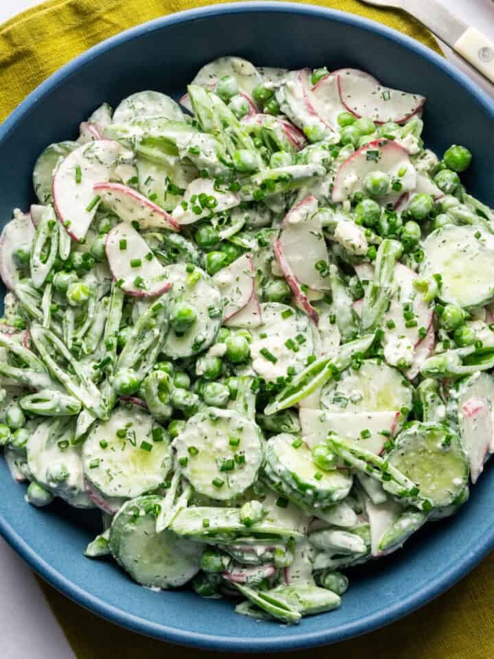 Overhead view of creamy cucumber pea salad in a bowl.