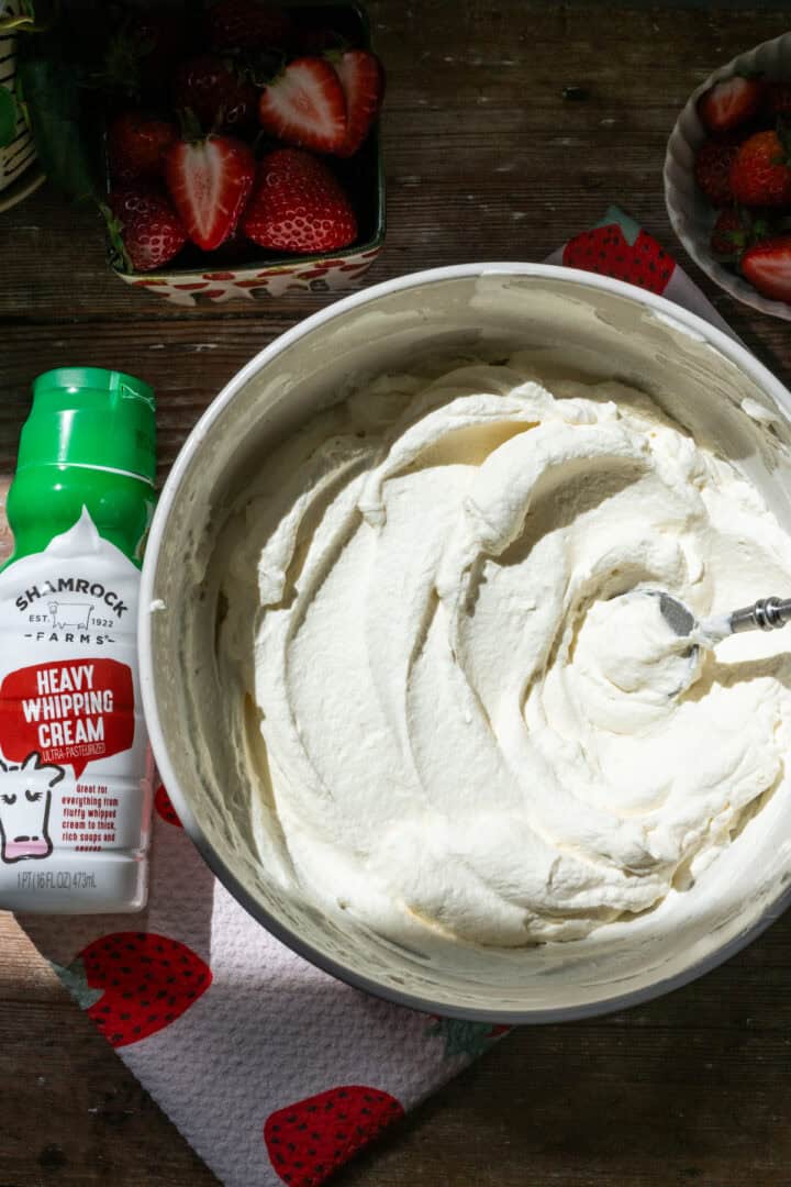Bowl of whipped cream next to a bottle of Shamrock Farms Heavy Whipping Cream.