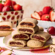 Close up side view of homemade strawberry nutrigrain bars stacked on a plate.