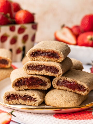 Close up side view of homemade strawberry nutrigrain bars stacked on a plate.