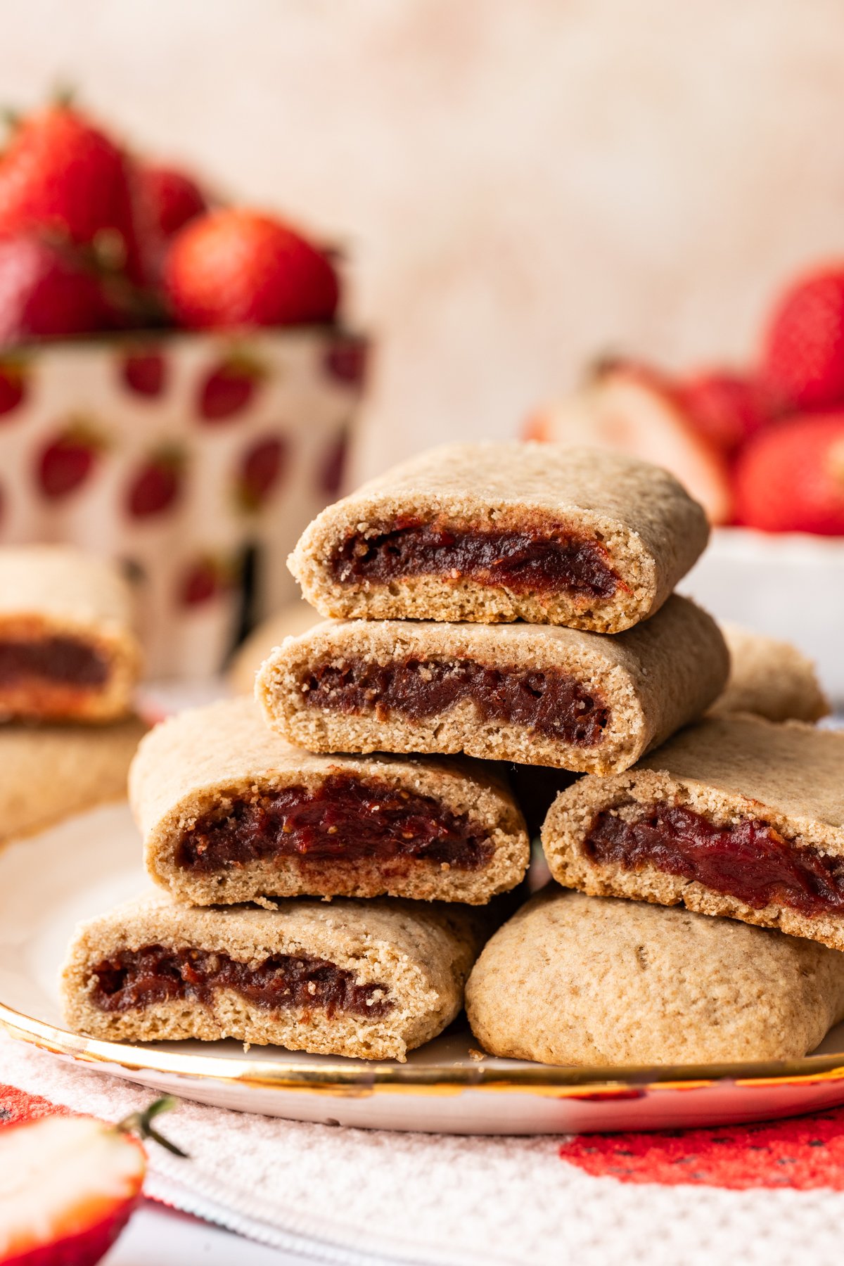 Close up side view of homemade strawberry nutrigrain bars stacked on a plate.