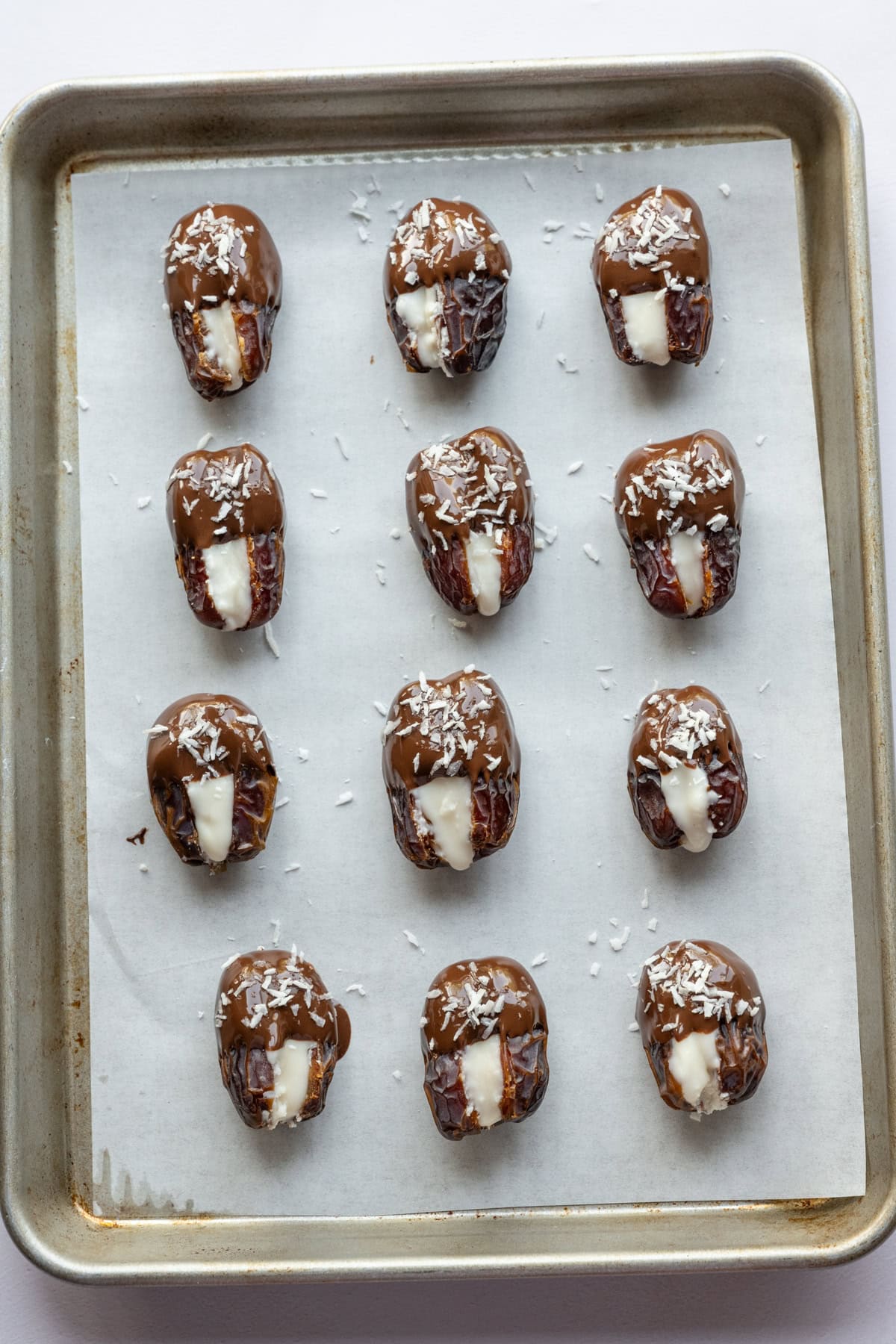 Coconut butter stuffed dates dipped in dark chocolate and sprinkled with more shredded coconut. 