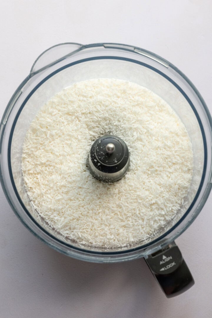Shredded coconut in food processor before blending. 