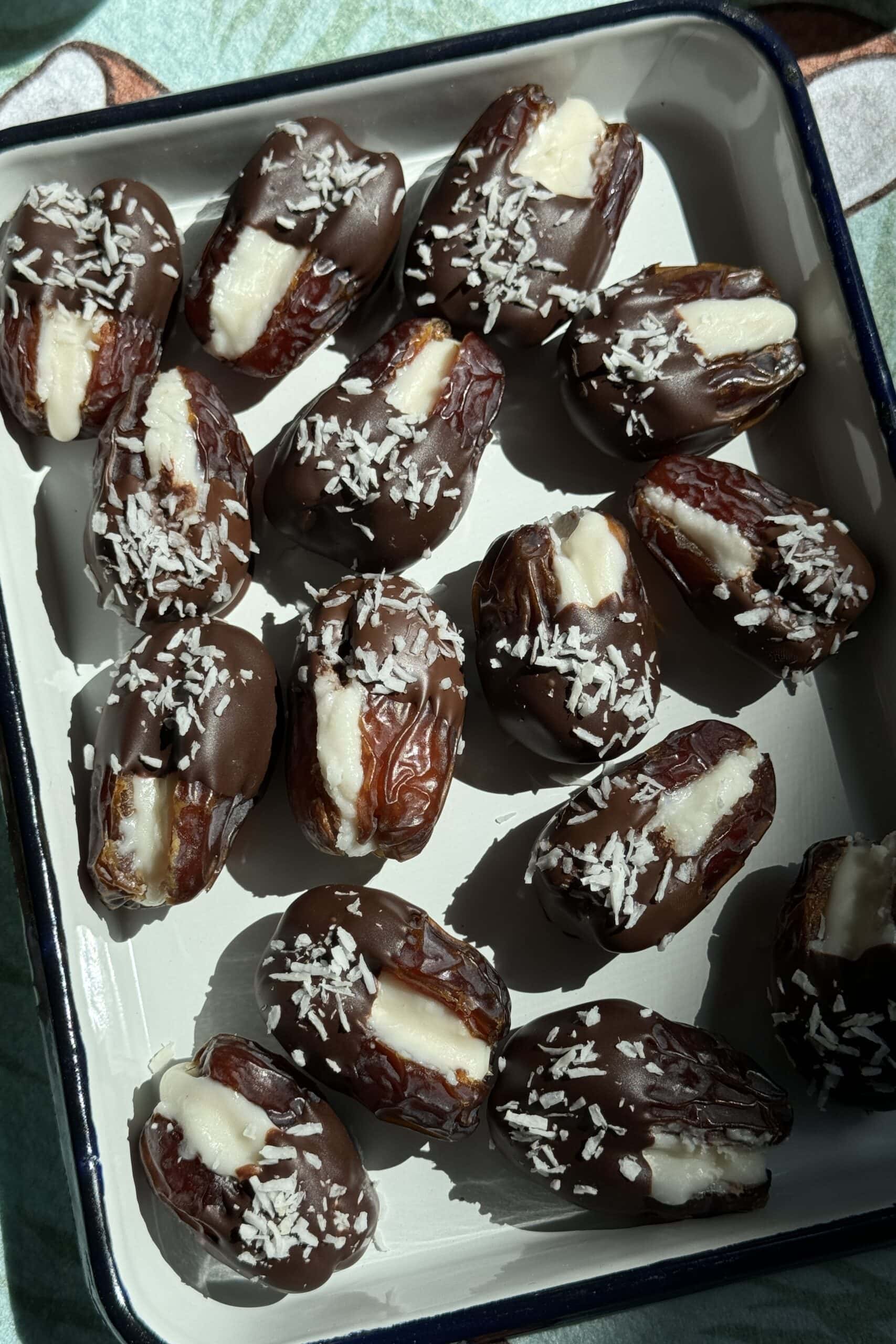 Overhead view of Mounds bar dates stuffed with coconut butter and dipped halfway in dark chocolate.