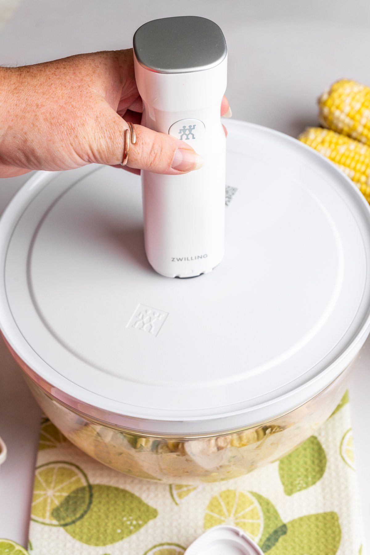 Vacuum sealing pasta salad in a glass bowl with Zwilling vacuum sealing attachment.