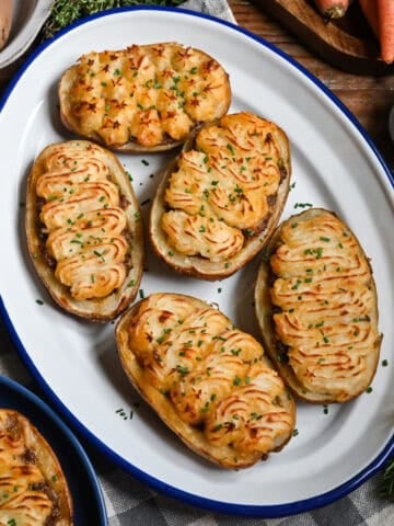Shepherd's pie twice baked potatoes on a tray with ingredients in the background.