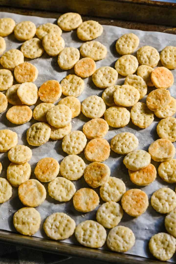 Homemade ritz crackers on parchment paper.