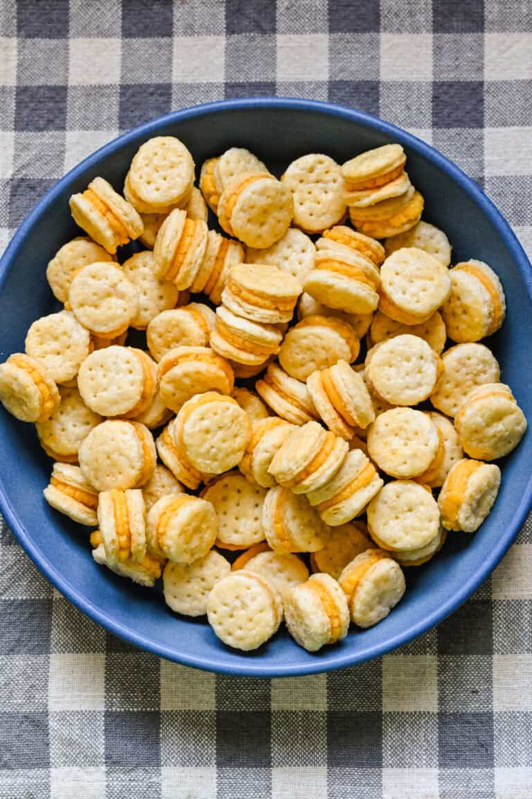 Overhead view of homemade ritz cheese cracker sandwiches in a blue bowl.