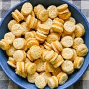 Overhead view of homemade ritz cheese cracker sandwiches in a blue bowl.
