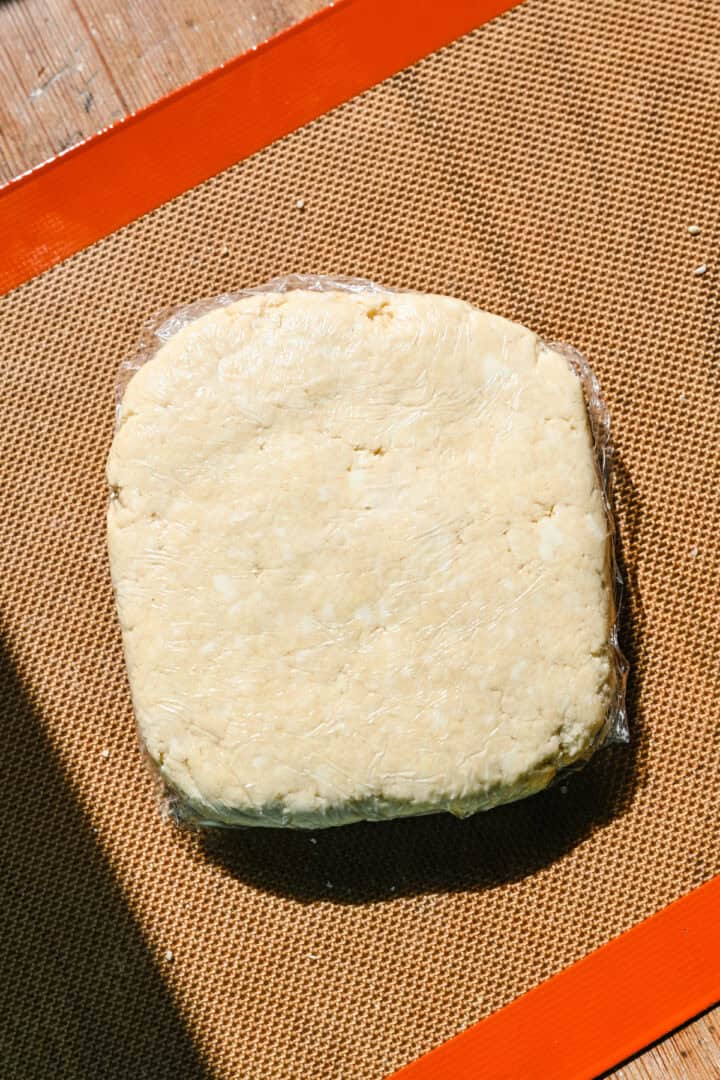 Cracker dough wrapped in plastic wrap in a rectangle.