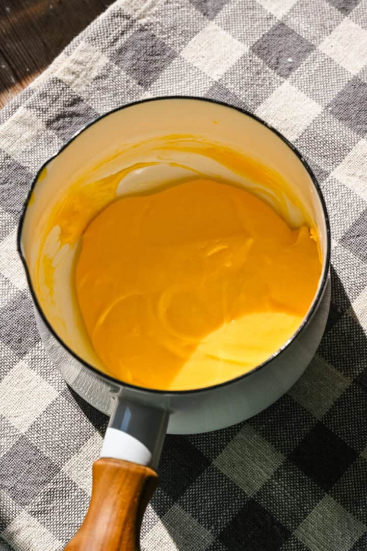 Thickened cheese sauce in small pot.