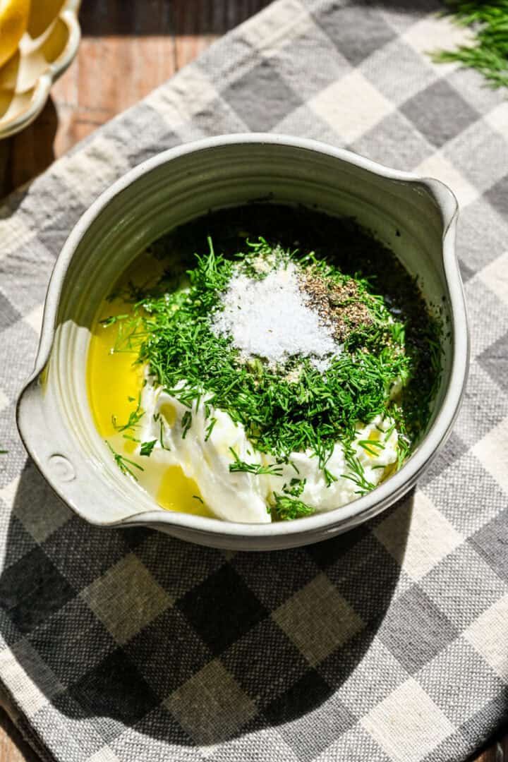 Yogurt dill sauce ingredients in a bowl before whisking together.