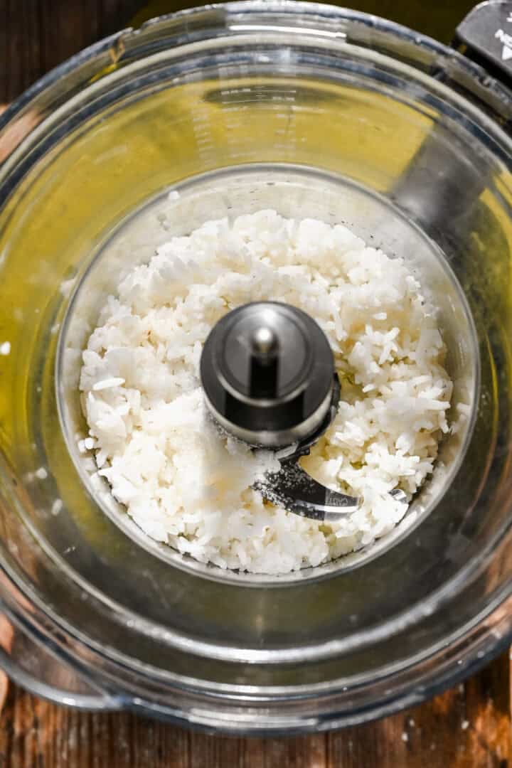 Overhead view of rice in a food processor bowl.