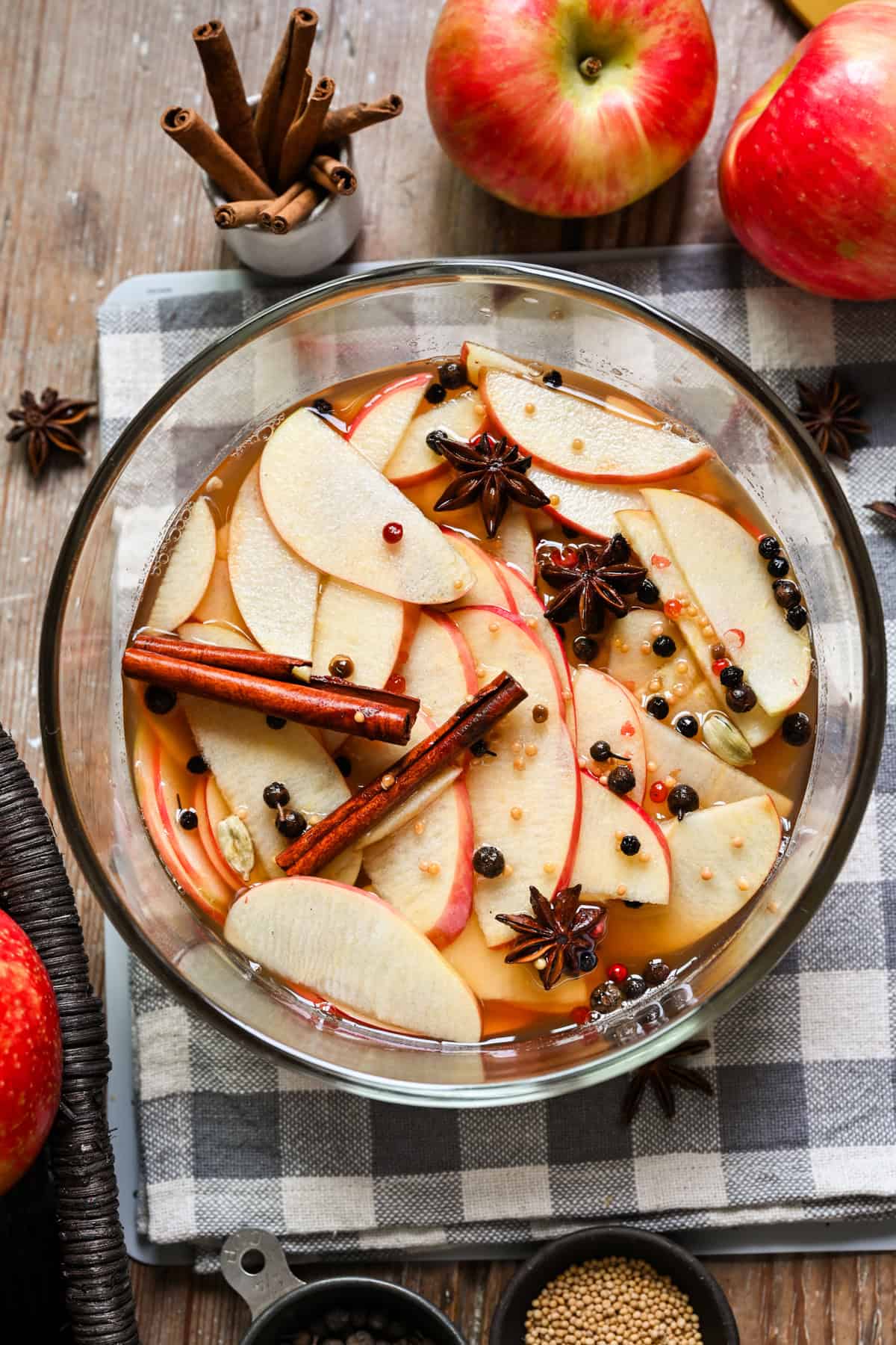 Overhead view of quick pickled apples with whole spices in a bowl.