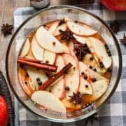 Overhead view of quick pickled apples with whole spices in a bowl.