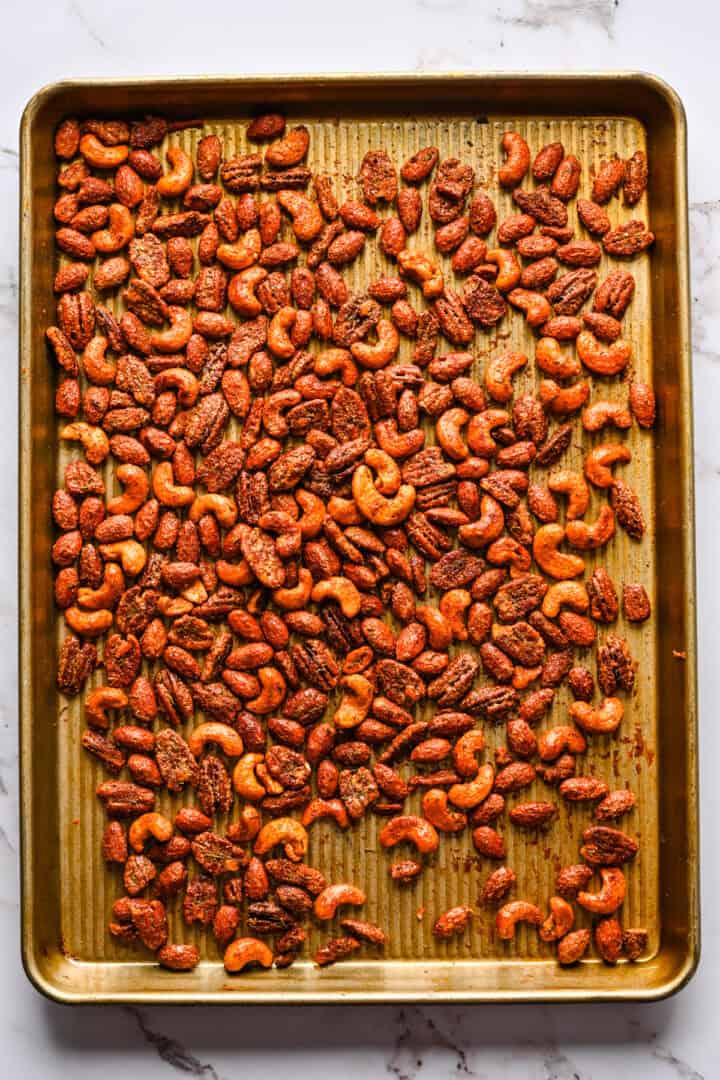 Overhead view of roasted nuts on a sheet pan.