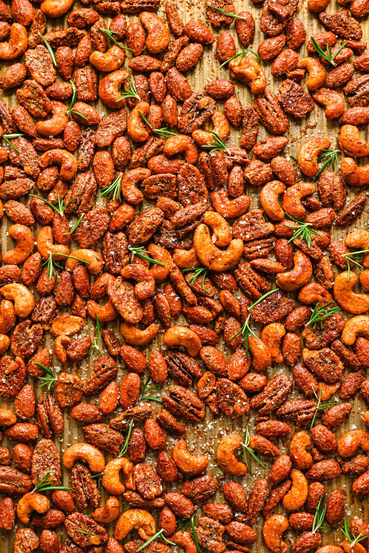 Overhead view of roasted nuts on a sheet pan.