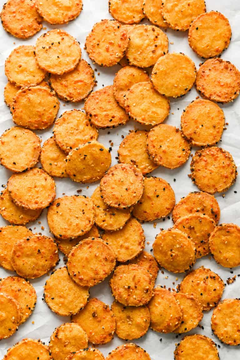 Overhead view of cheddar cheese coins on parchment.