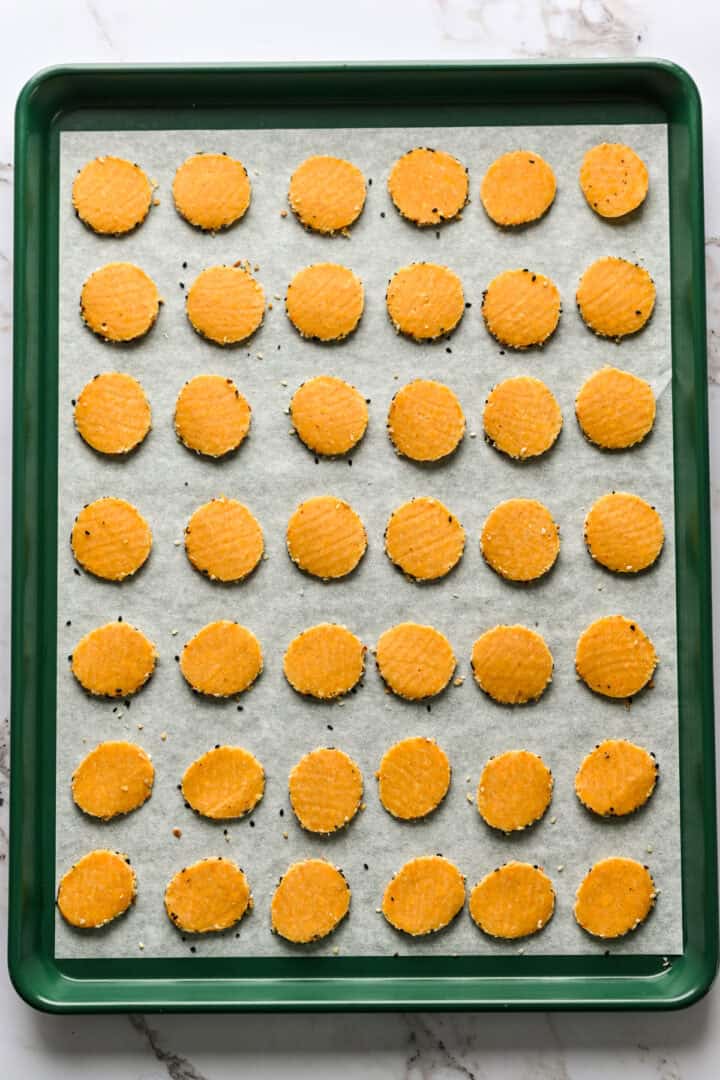 Overhead view of cheddar cheese coins before baking.