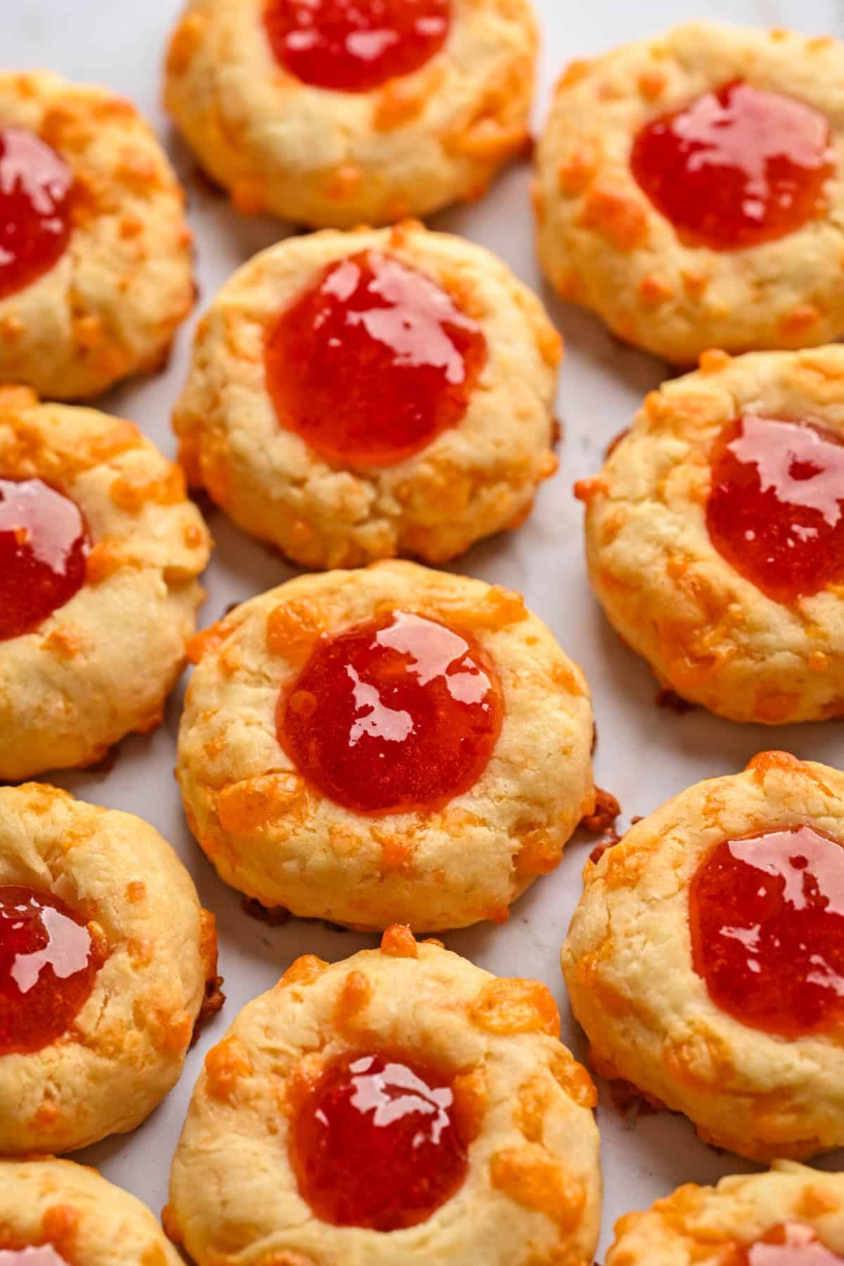 Overhead view of cheesy thumbprints on a sheet pan.
