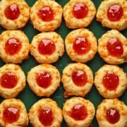 Overhead view of cheesy thumbprints on a sheet pan.