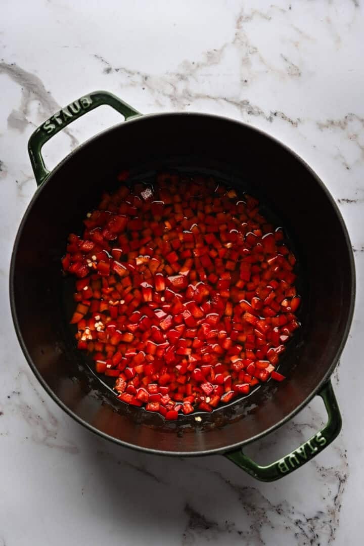 Diced red pepper in a black pot.